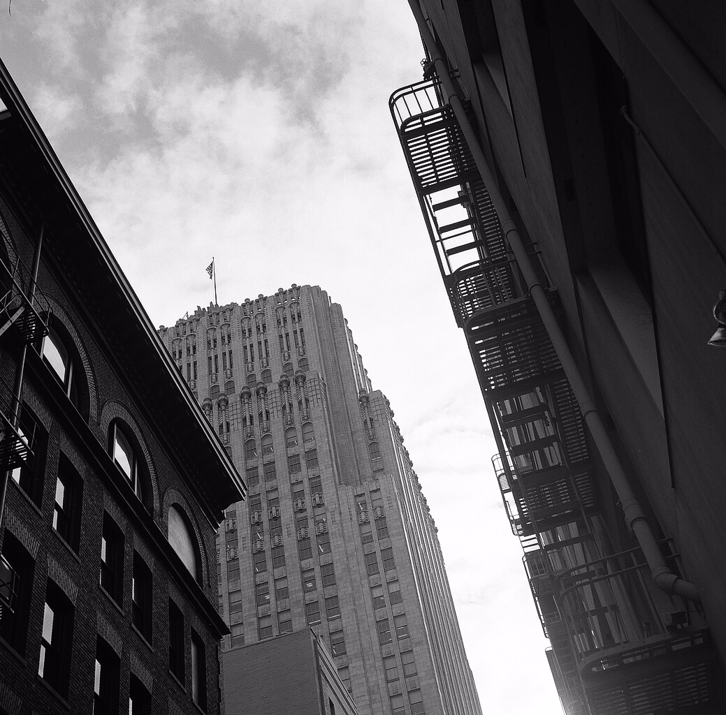 a photo taken from downtown San Francisco, looking through buildings up to the sky. shot with a Voigtländer Perkeo, Tmax 400